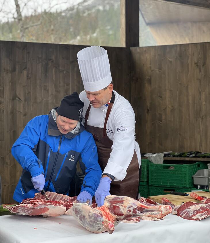 Bilde av kokkene for dagen. Hans Antonsen og Svein Jæger som serverte mat for dagen. Her serverer de buljong med varmrøkt reinsdyrhjerte og tunge.